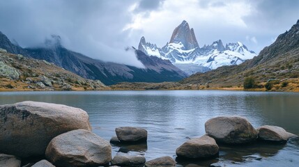 Scenic rocky lakeshore featuring majestic mountains beneath a dramatic cloudy sky
