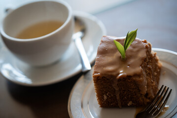 Delicious tea cake with tea leaves and cup of hot tea