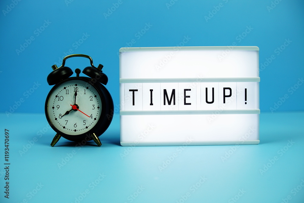 Poster time up! letterboard text on led lightbox and alarm clock on blue background