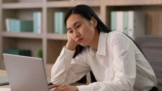 Lazy bored sad Asian Japanese businesswoman female girl upset Chinese Korean business woman worker employer CEO boring online work laptop pc boredom mental health overworked problem burnout in office