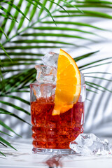 Mezcal negroni, alcoholic cocktail drink with agave spirit, red bitters, sweet vermouth, ice and...