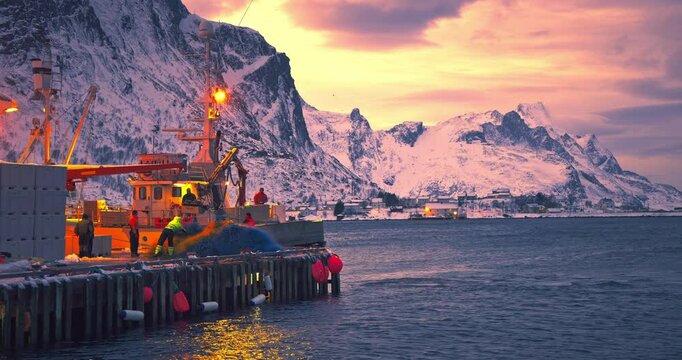 Fishermen, nets, fishing boat on arctic sea harbor, Lofoten Islands, Norway, Europe, Mountains hills and arctic fjords sunset landscape