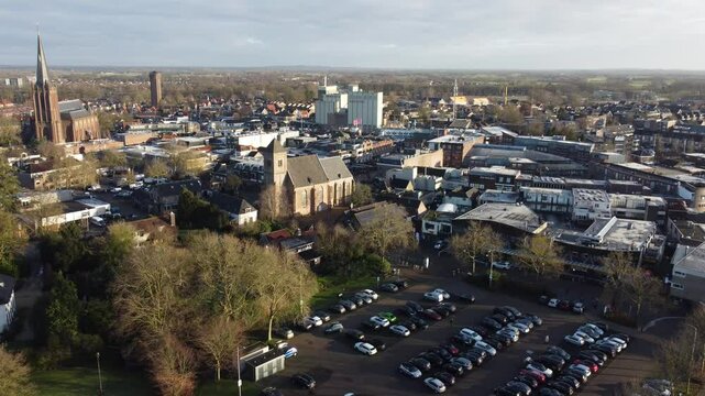 Raalte, the Netherlands - January 10th 2025: Aerial footage of the town center. Drone flying backwards over mayor parking lots.