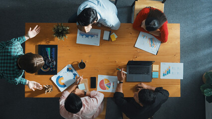 Top down view of manager holds tablet display increasing sales and placed on meeting table. Group of diverse business team clapping hands to celebrate successful product at meeting room Convocation.