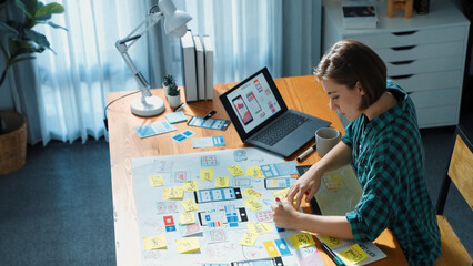 Top view of manager design UX, UI system while sitting at table and looking at tablet with program...