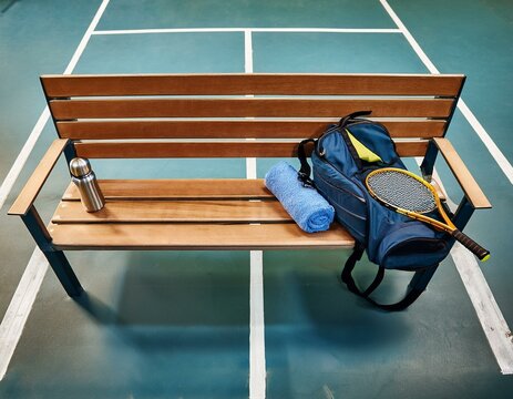 Generated image An overhead shot of a court bench with a sport bag, racket, and water bottle