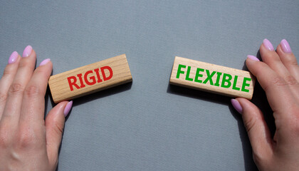 Rigid or Flexible symbol. Concept word Rigid or Flexible on wooden blocks. Businessman hand. Beautiful grey background. Business and Rigid or Flexible concept. Copy space