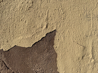 Textured wall with peeling paint in rustic earth tones