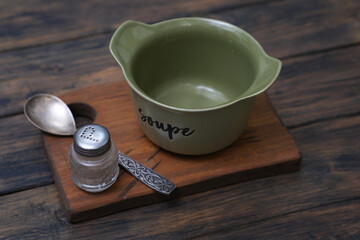 A beautifully crafted Vintage Green Soup Bowl accompanied by Salt and Spoon placed on a Wooden Board