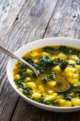 Portuguese green soup - Caldo Verde. Potato and kale soup on wooden table