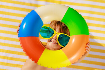 Top view portrait of happy child lying on beach towel on summer vacation