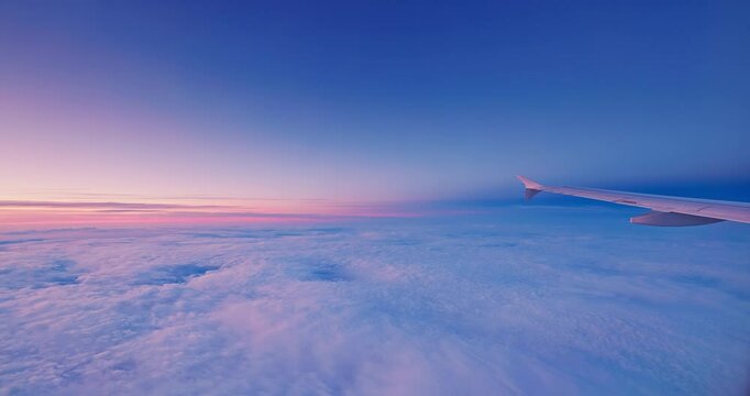 Flying with airplane in color sunset sky with clouds