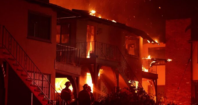 Altadena, California, USA - January 8, 2025: Firefighters work to put out a blaze at an apartment complex caused by the Eaton Fire.