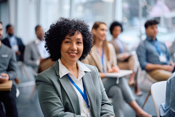Portrait of happy mature businesswoman attending seminar in board room and looking at camera.
