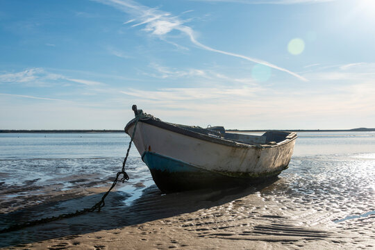 old wooden boat sitting on a beach low tide