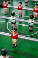 Foosball table with players representing Sport Lisboa e Benfica and Sporting Clube de Portugal, highlighting a friendly football rivalry in a playful setting.