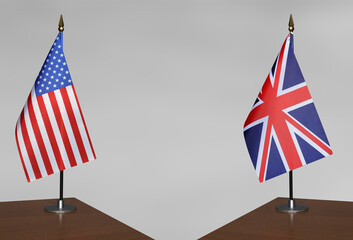 Tabletop flags of USA and United Kingdom on stands on a gray blurred background