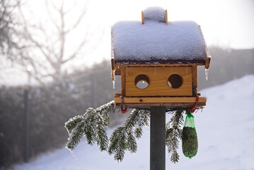 Vereistes Vogelhaus mit Eiszapfen als Futterstelle