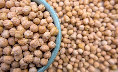 White Chickpeas, Garbanzo Beans, Ceci Beans, or Egyptian Peas, Kabuli Peas in a Light Blue Bowl on a Blurred Background