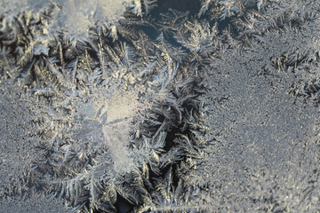 Close-Up Frost Crystals on Frozen Window Showcasing Intricate Winter Patterns