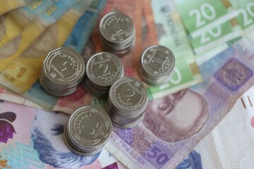 Few stacks of ukrainian money coins lies on old hryvnia banknotes