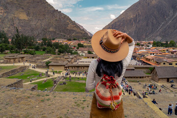 Latin tourist looking at the town of Ollantaytambo from the Ollantaytambo fortress