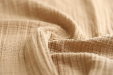 Texture of crumpled linen fabric under natural light in peach fuzz color