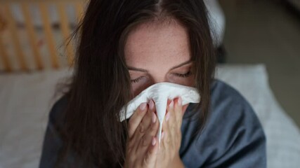 Sick woman blowing nose in hotel room - Powered by Adobe