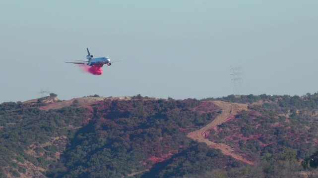 In Los Angeles, a vital firefighting plane is conducting aerial operations above rugged mountains to combat severe wildfires threatening nearby homes and communities with destruction