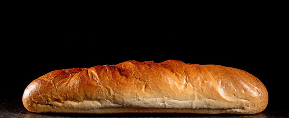 French loaf on black background, frontal view