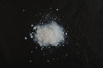 Pile of Colloidal silicon dioxide on black stone surface, top view. Enterosorbent. Powder for...