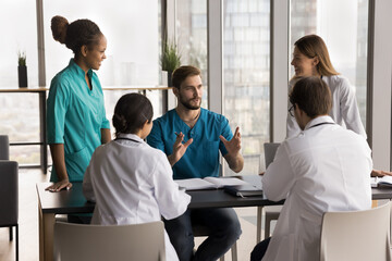 Doctors gathered together engaged in healthcare concilium, creating or adjusting treatment plans...