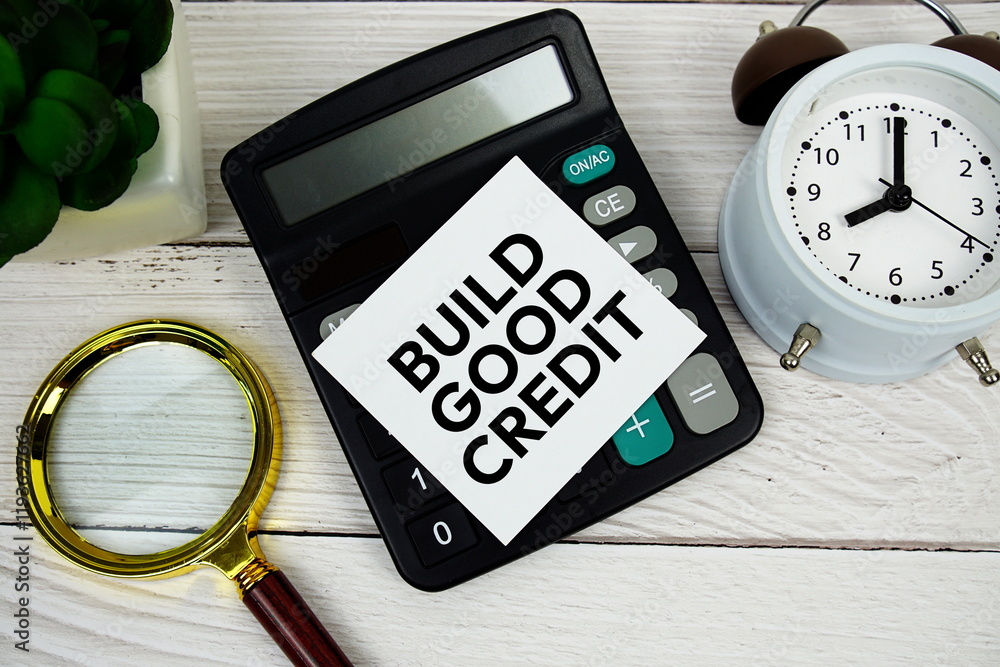 Poster build good credit text message with calculate, alarm clock and magnifying glass on wooden background