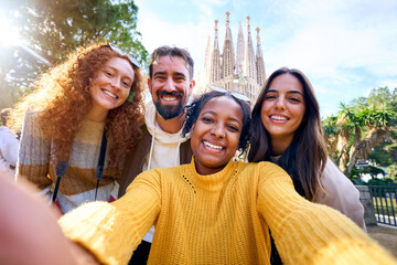 Group diverse funny young tourist friends posing piggyback with hands joined in air taking selfie...