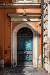 Fototapeta premium Decorative arched blue door and an orange building