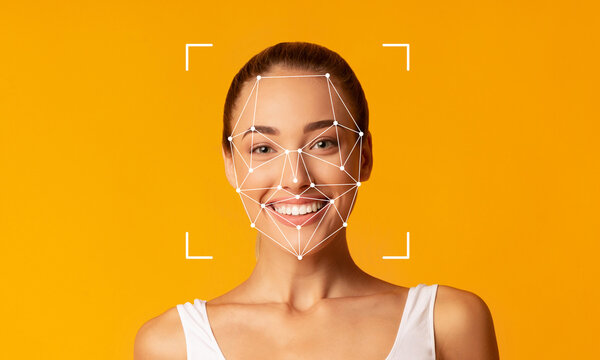 Fototapeta A smiling woman stands in front of a bright yellow background, demonstrating facial recognition technology. The facial features are highlighted with geometric patterns, indicating ID capabilities.