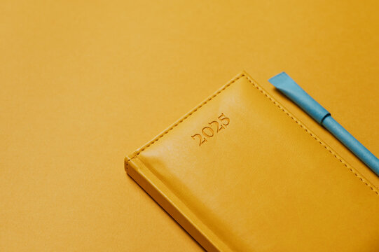 yellow notepad 2025 blue pen on a yellow background
