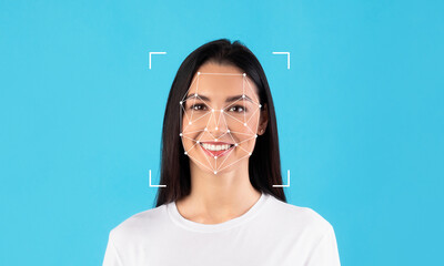 A woman with long dark hair smiles as facial recognition technology analyzes her features. The...