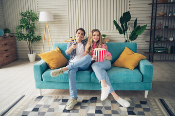 Obraz premium Two young people enjoying popcorn together in a cozy living room