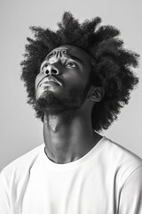 Black and white portrait of a man in a white shirt looking upward, expressing contemplation and introspection.
