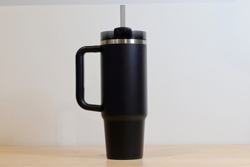 Isolated Black Insulated Tumbler with Straw Against White Background. Reusable, Eco-friendly, and...