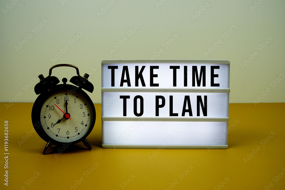 Poster take time to plan text on led lightbox with alarm clock on yellow background