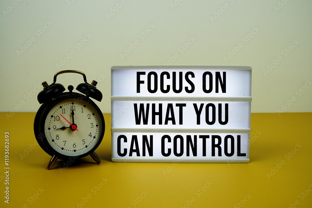 Poster focus on what you can control text on led lightbox with trolley shopping cart on yellow background