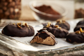 Bite of a homemade healthy sweet dessert made of greek yogurt, nut butter and maple syrup coated in chocolate