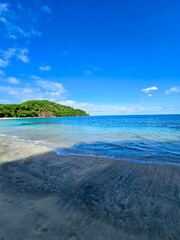 Blanca Beach and the blue waters of Culebra Bay, lush green trees, blue sky and clouds in Liberia Guanacaste Costa Rica