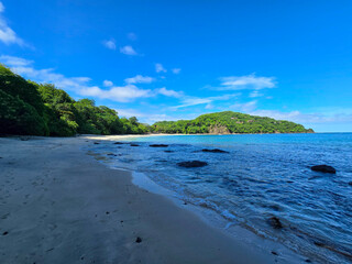 Blanca Beach and the blue waters of Culebra Bay, lush green trees, blue sky and clouds in Liberia Guanacaste Costa Ric