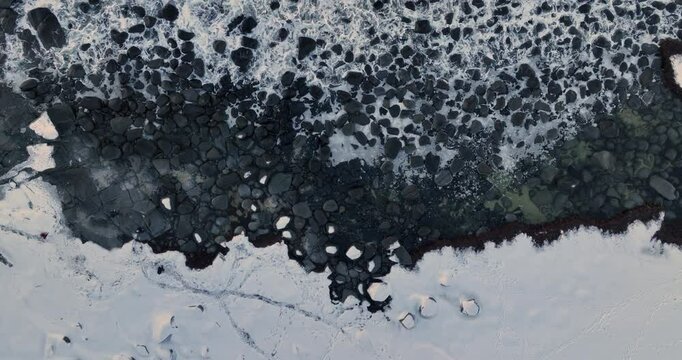 Water Background Surface of frosty stones and rocks and sea waves on the artic beach shore