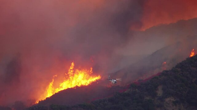 In the year January 7, 8, 9, 2025, wildfires rage throughout Malibu and Los Angeles, showcased in breathtaking 4K footage that illustrates helicopters fiercely battling the unyielding flames