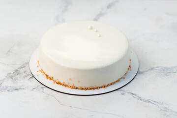 Simple white mousse cake decorated with dried waffle crumbs and covered with smooth chocolate...