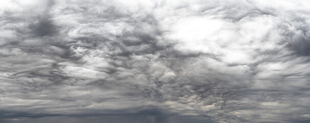 Panorama of dramatic storm clouds that fade to transparent in light areas near top right
